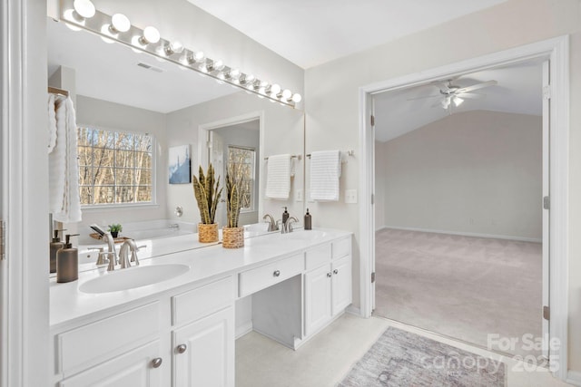 bathroom featuring a tub, ceiling fan, vanity, and lofted ceiling