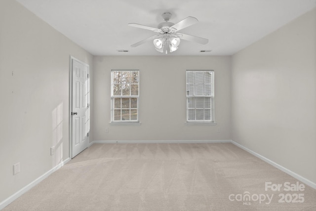 spare room with light colored carpet and ceiling fan