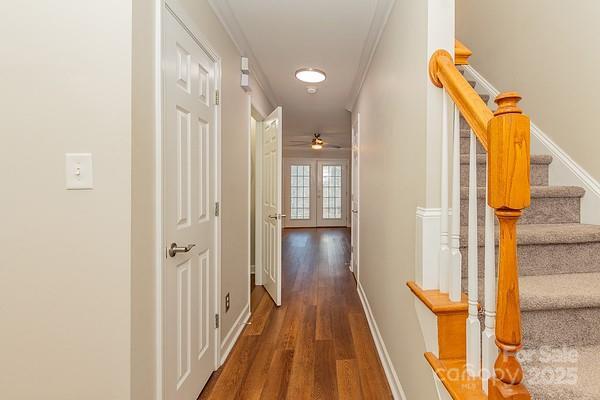 hallway with french doors, dark hardwood / wood-style flooring, and crown molding