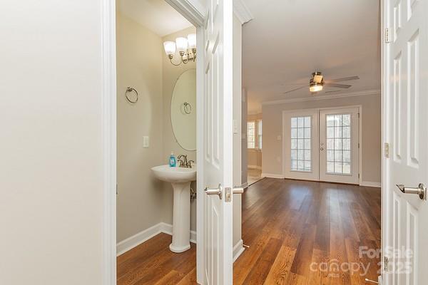 bathroom with sink, crown molding, hardwood / wood-style flooring, ceiling fan, and french doors