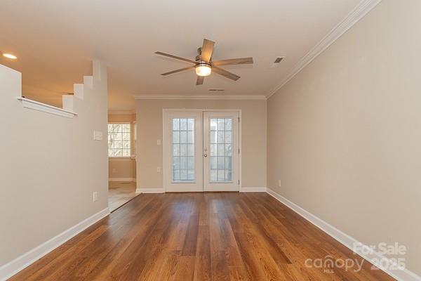 spare room featuring hardwood / wood-style floors, ornamental molding, french doors, and ceiling fan