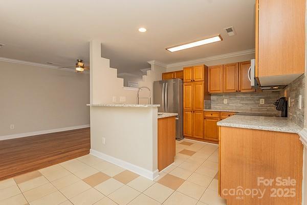 kitchen featuring ornamental molding, appliances with stainless steel finishes, and backsplash