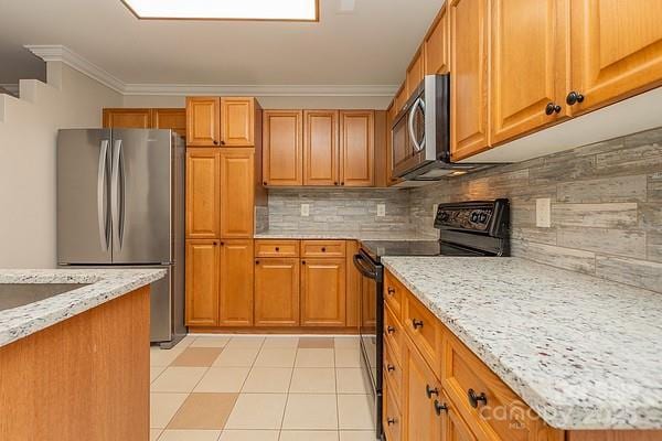 kitchen with crown molding, appliances with stainless steel finishes, light stone counters, and decorative backsplash