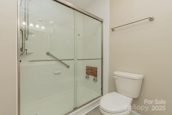 bathroom featuring walk in shower and toilet