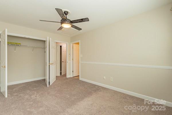 unfurnished bedroom featuring ceiling fan, light colored carpet, and a closet