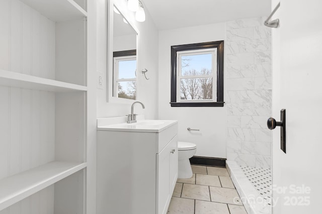 bathroom with vanity, a tile shower, and toilet