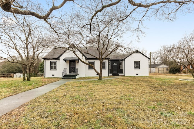 view of front of property featuring a front yard, crawl space, brick siding, and roof with shingles