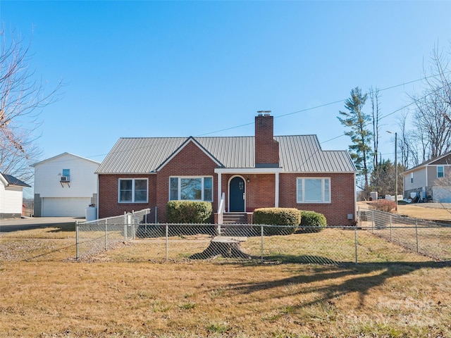 view of front facade with a chimney, a front lawn, a fenced front yard, brick siding, and metal roof