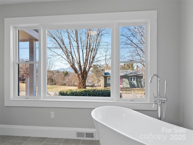 bathroom featuring tile patterned flooring and a bath