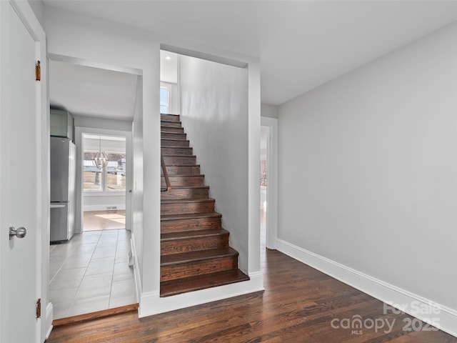 stairway featuring a notable chandelier and hardwood / wood-style flooring