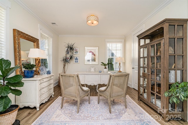 office area with ornamental molding and light hardwood / wood-style flooring