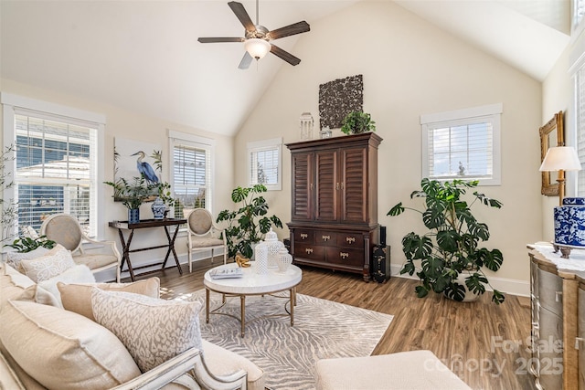 living area with ceiling fan, wood-type flooring, and high vaulted ceiling