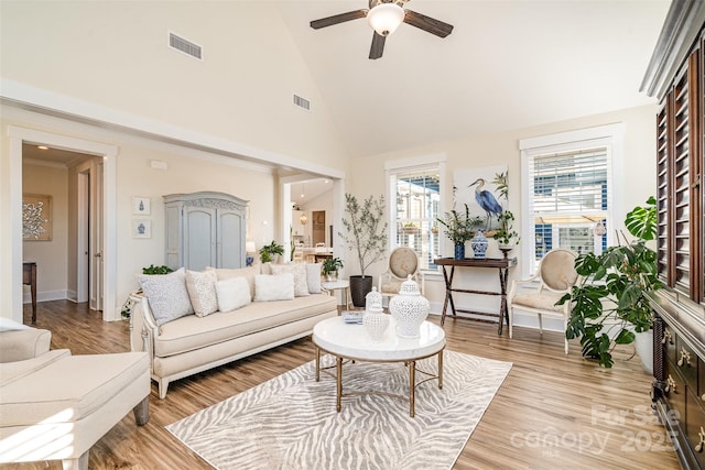 living room with ceiling fan, high vaulted ceiling, and light wood-type flooring