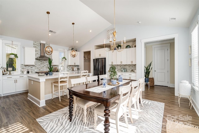 dining space with lofted ceiling, dark hardwood / wood-style floors, and a notable chandelier