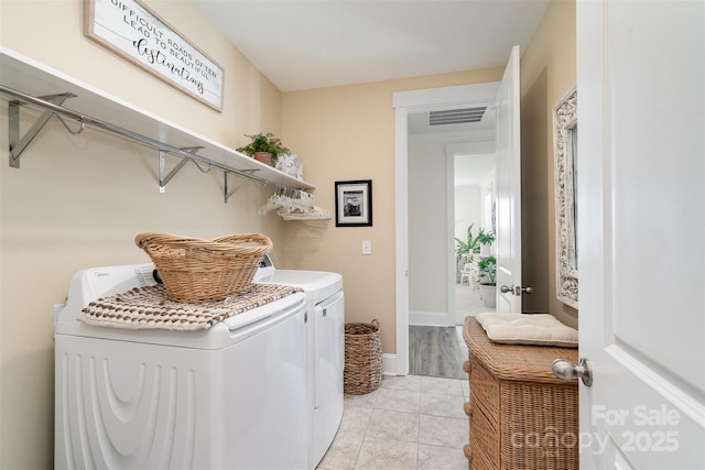 laundry room with washing machine and dryer and light tile patterned floors