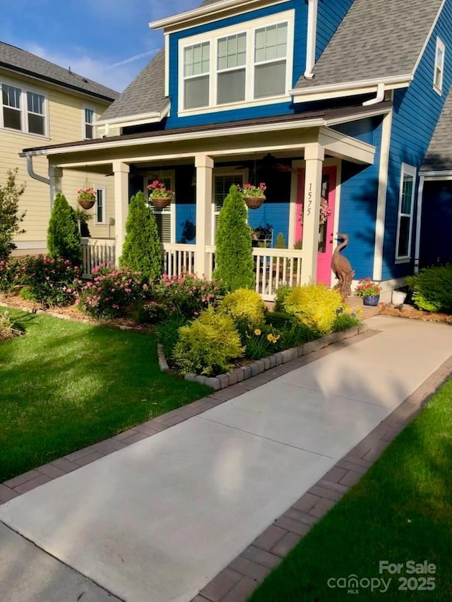 view of front facade with a front yard and covered porch