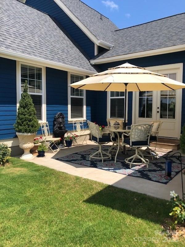 rear view of property with a yard and a patio area