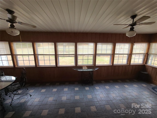 unfurnished sunroom featuring wood ceiling and ceiling fan