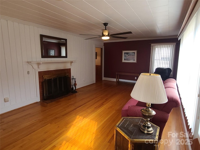 living room with hardwood / wood-style floors, a brick fireplace, and ceiling fan