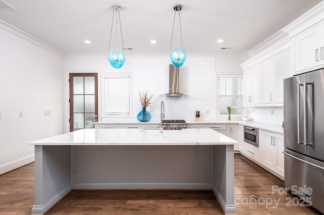 kitchen with wall chimney exhaust hood, stainless steel appliances, a center island, and white cabinets