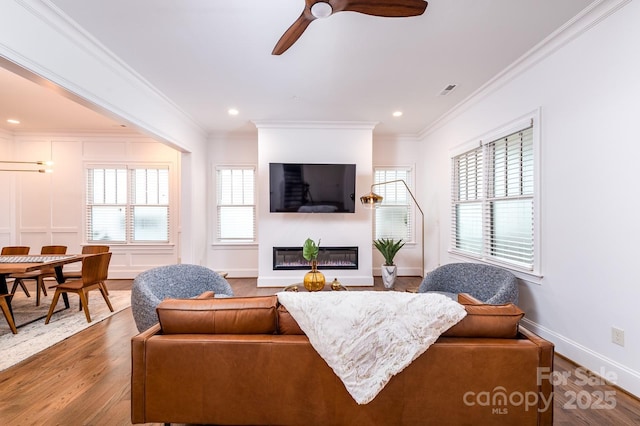 living room with ornamental molding, dark hardwood / wood-style floors, and ceiling fan