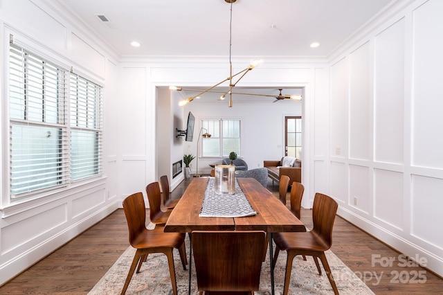 dining space with crown molding, dark hardwood / wood-style floors, and an inviting chandelier