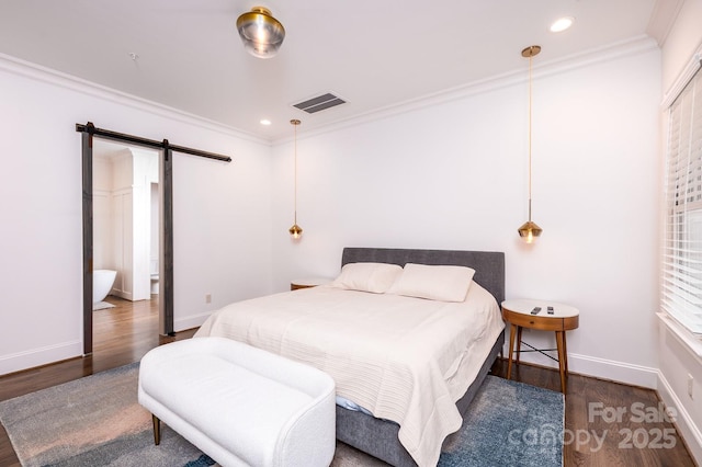 bedroom featuring dark wood-type flooring, ornamental molding, and a barn door