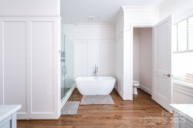 full bathroom featuring toilet, crown molding, vanity, hardwood / wood-style flooring, and plus walk in shower