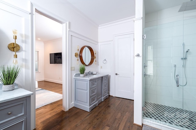 bathroom featuring crown molding, vanity, a shower with shower door, and hardwood / wood-style flooring