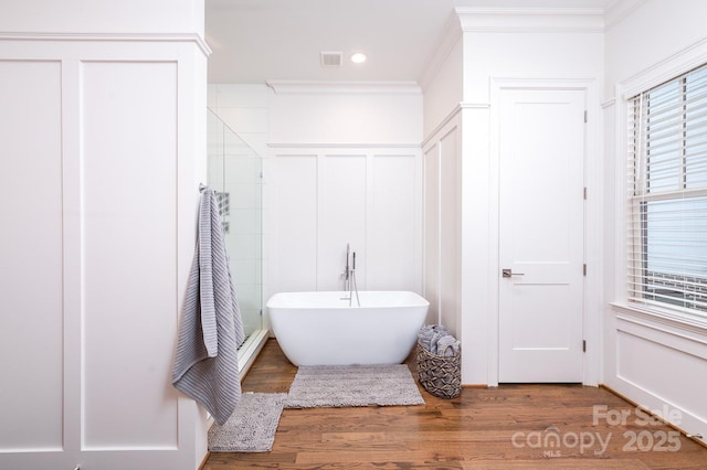 bathroom with hardwood / wood-style floors, crown molding, and plus walk in shower