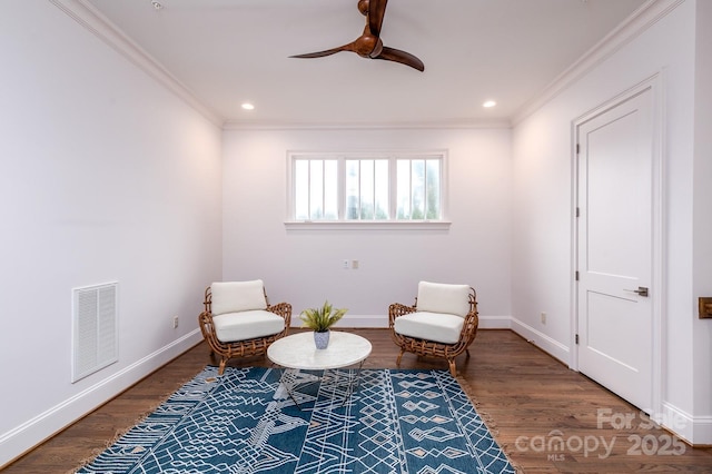 sitting room with wood-type flooring, ornamental molding, and ceiling fan