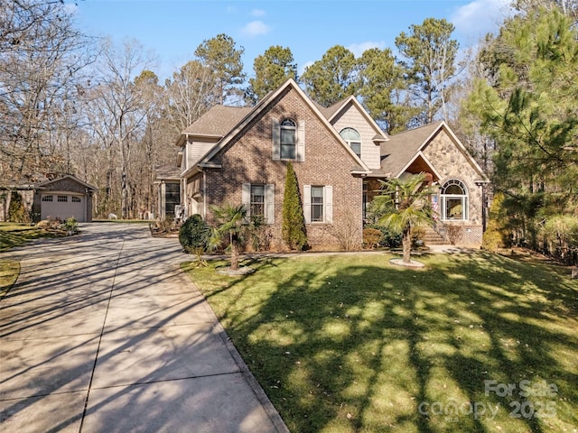 front facade with a garage, an outdoor structure, and a front yard