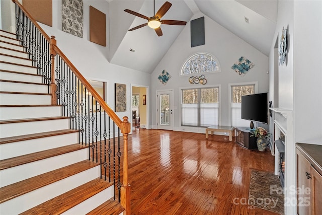 living room featuring ceiling fan, wood-type flooring, and high vaulted ceiling