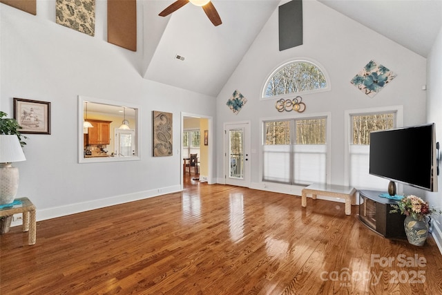 living room with hardwood / wood-style flooring, high vaulted ceiling, and ceiling fan