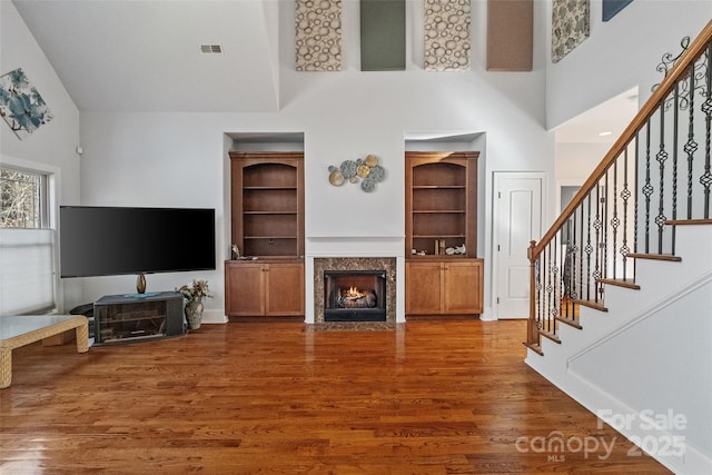 living room featuring dark wood-type flooring and a high ceiling