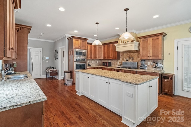 kitchen with appliances with stainless steel finishes, white cabinetry, sink, hanging light fixtures, and light stone counters