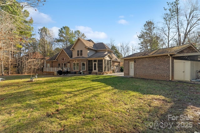 back of house with a yard and a sunroom