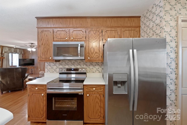 kitchen with stainless steel appliances, ceiling fan, and a textured ceiling