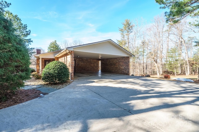 2076 Jay Clark Rd, Morganton, NC 28655 - view of side of home featuring concrete driveway, brick siding, a chimney, and an attached carport