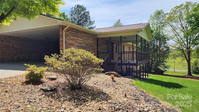 2076 Jay Clark Rd, Morganton, NC 28655 - view of property exterior featuring a yard, brick siding, driveway, and a carport