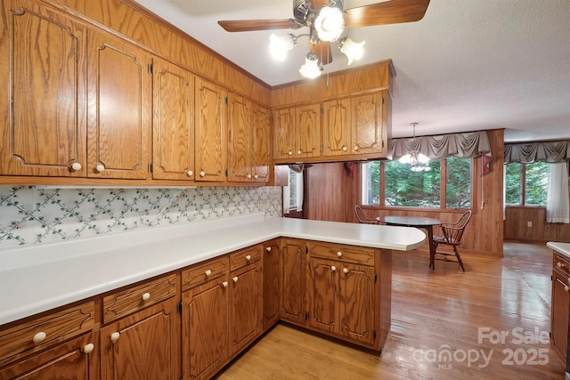 2076 Jay Clark Rd, Morganton, NC 28655 - kitchen featuring a peninsula, light countertops, brown cabinetry, and light wood-style flooring
