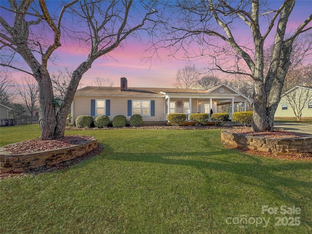 ranch-style home featuring a porch and a yard