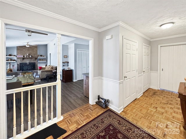 hallway with ornamental molding, parquet floors, and a textured ceiling