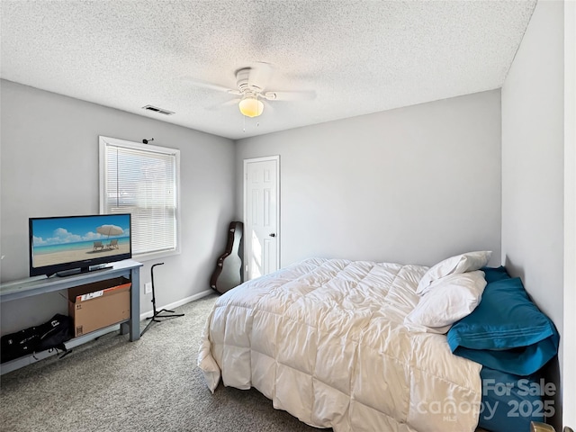 bedroom with ceiling fan, carpet, and a textured ceiling