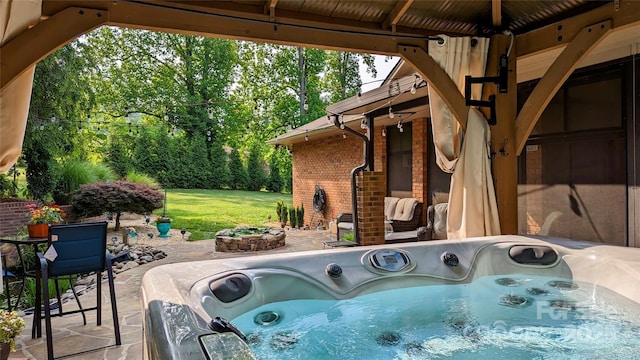 view of patio / terrace featuring a fire pit and a hot tub