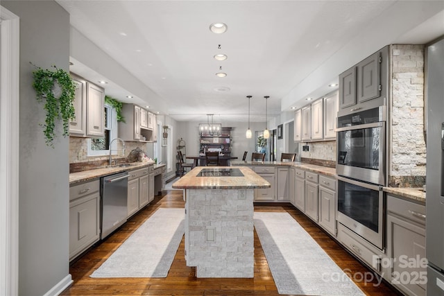 kitchen featuring stainless steel appliances, a kitchen island, sink, and gray cabinets