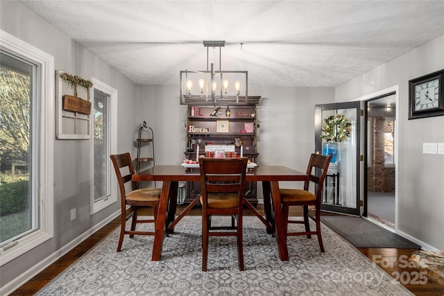 dining room featuring hardwood / wood-style flooring, a textured ceiling, and a chandelier