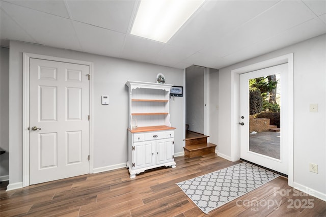 interior space with dark wood-type flooring and a paneled ceiling