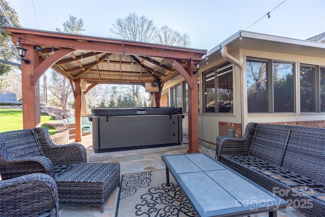 view of patio / terrace featuring a gazebo, an outdoor hangout area, and a hot tub