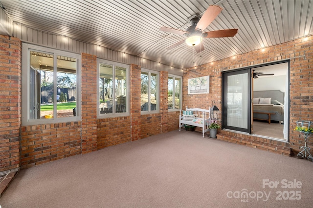 unfurnished sunroom featuring ceiling fan